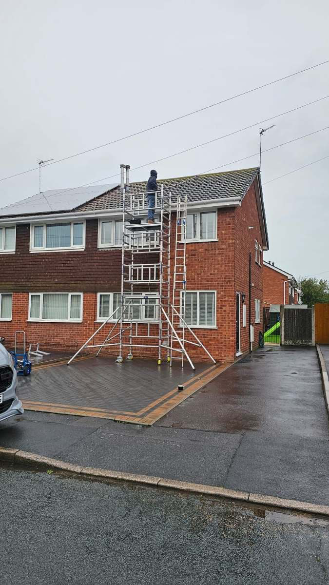 Roofer working from a scaffold tower on a Staffordshire semi-detached home